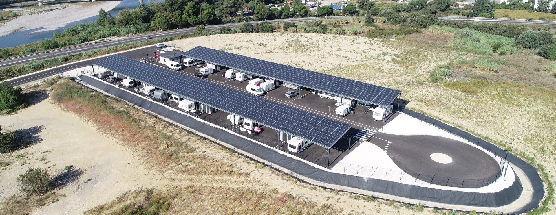 Vue par le ciel (drone) de l'aire d'accueil des gens du voyage à Cavaillon, située en bord de Durance et équipée d'ombrières photovoltaïques.