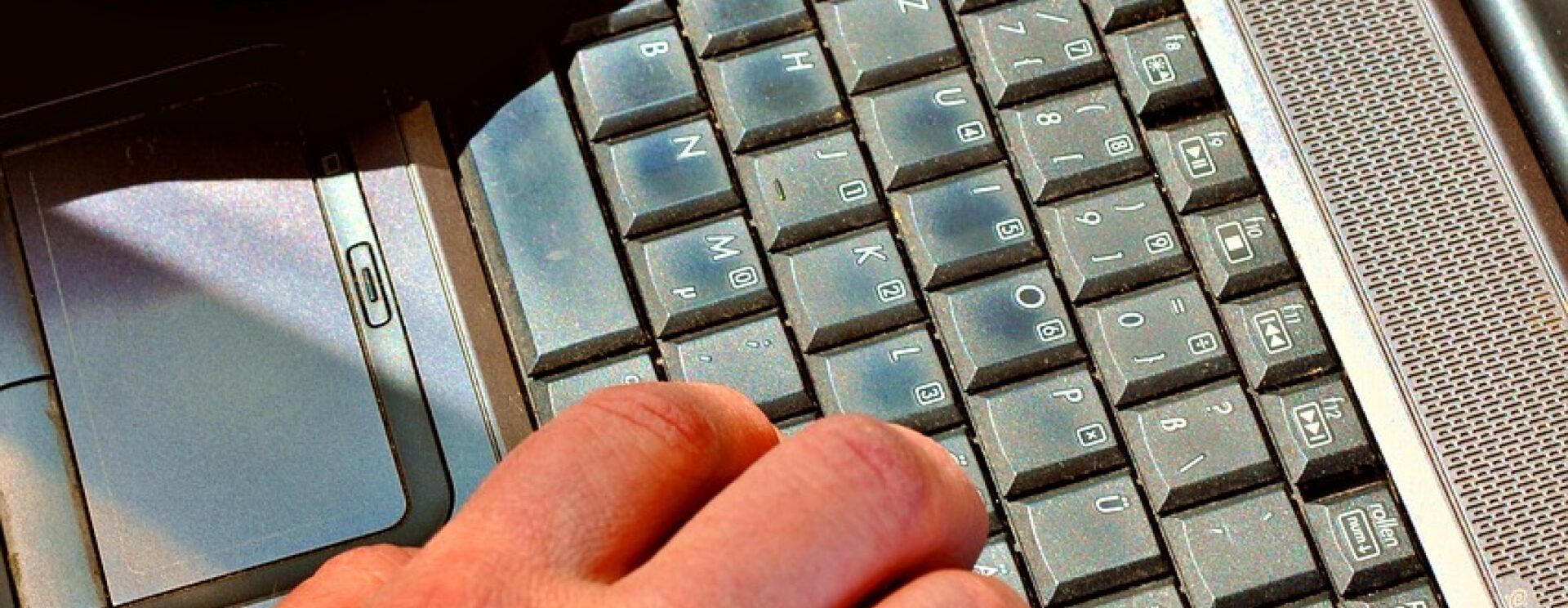 Gros plan de mains tapant sur un clavier d'ordinateur