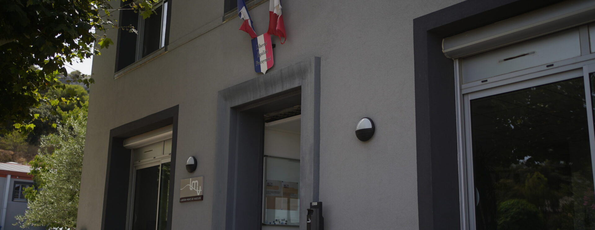 Photo de l'entrée du siège de LMV surplombée par deux drapeaux français