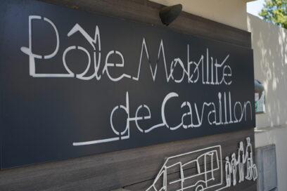 Gros plan de la plaque signalétique du Pôle Mobilité de Cavaillon, écrite en fil de fer tordu et avec dessous un bus et une famille dessinée de la même façon - Agrandir l'image, fenêtre modale