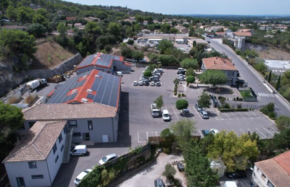 Vue drone du siège LMV avec ses trois bâtiments dont deux sont équipés de panneaux solaires et son parking