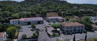 Vue drone du siège LMV avec ses trois bâtiments dont deux sont équipés de panneaux solaires et son parking