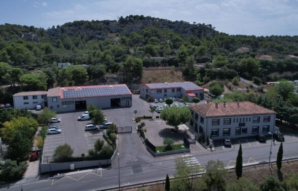 Vue drone du siège LMV avec ses trois bâtiments dont deux sont équipés de panneaux solaires et son parking