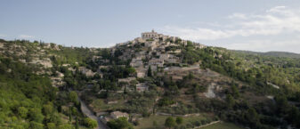 Vue de Gordes prise par un drone. Au premier plan, la plaine, au second: le rocher avec le château de Gordes.
