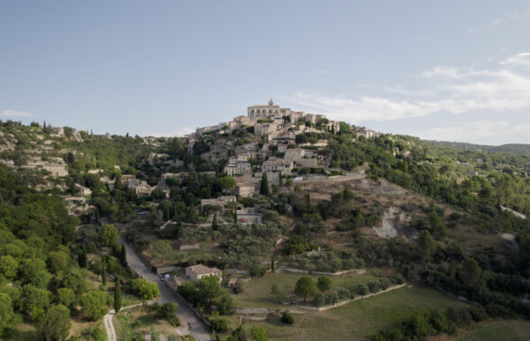Vue de Gordes prise par un drone. Au premier plan, la plaine, au second: le rocher avec le château de Gordes.