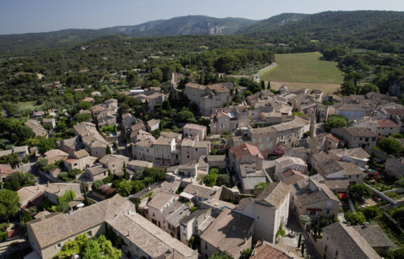 Vue de Lagnes en drone. Au premier plan : le centre ville. au second : la plaine et les Monts de Vaucluse en fond