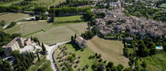 Lourmarin vue d'un drone. A gauche de l'image : le château. Au centre : la plaine. A droite : le village