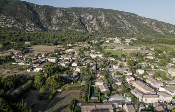 Maubec vue du ciel. Au premier plan : la commune. Au second: le Luberon