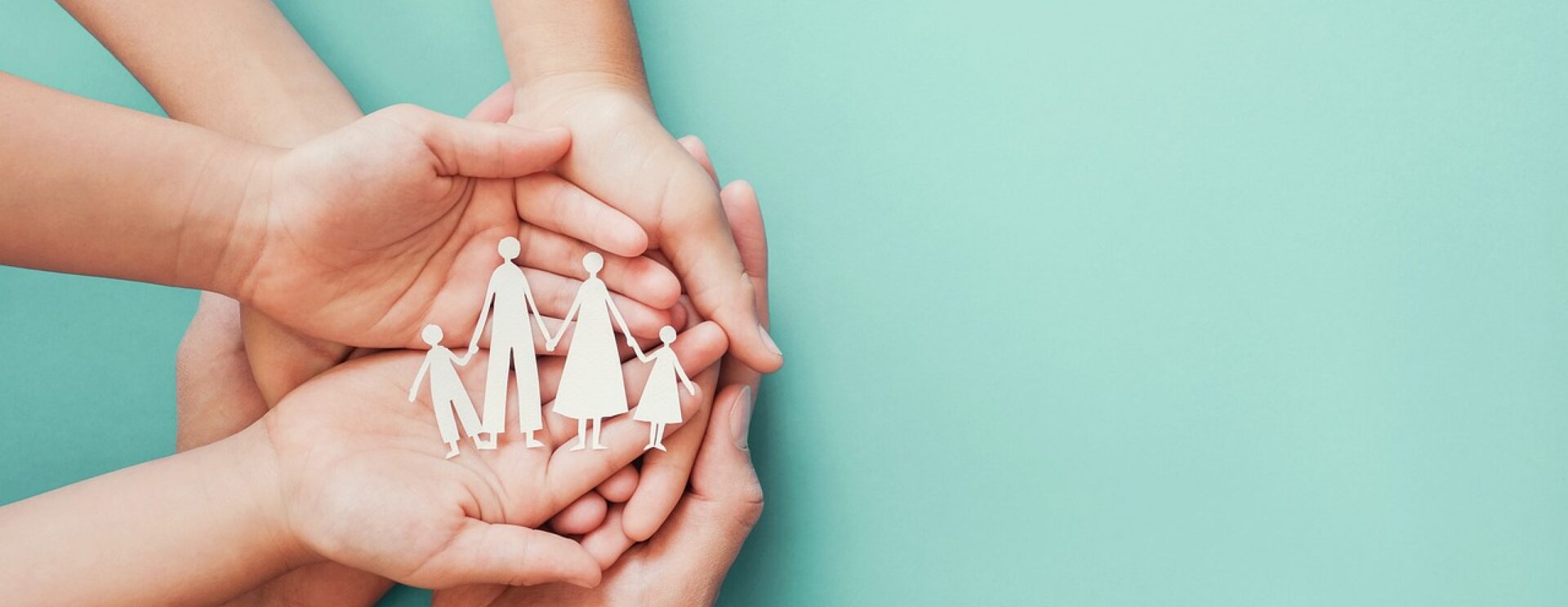 Gros plans sur 4 mains à l’intérieur desquelles on voit 4 silhouettes en cartons représentant les membres de la famille