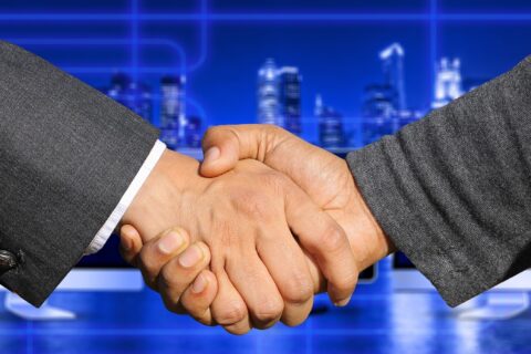 Poignées de mains de deux hommes adultes en costume