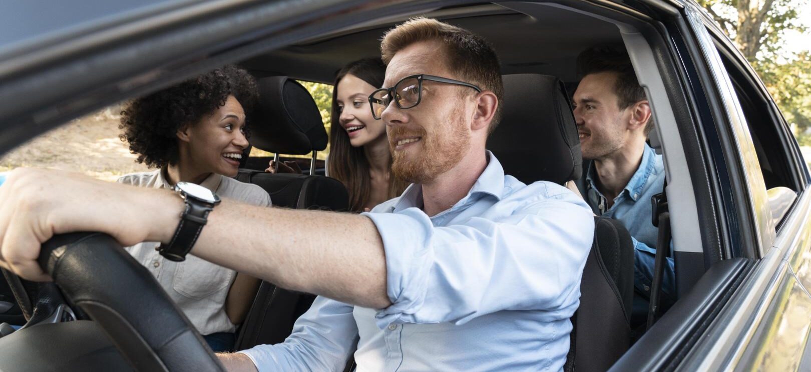 Plusieurs personnes souriantes installées dans une voiture