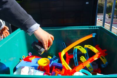 Une personne en train de déposer un jouet dans un bac de collecte spécifique à la récolte de jouets - Agrandir l'image 1 sur 2, fenêtre modale