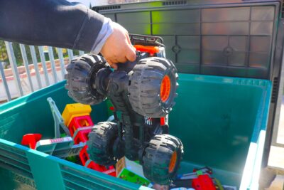 Une personne en train de déposer un jouet dans un bac de collecte spécifique à la récolte de jouets - Agrandir l'image 2 sur 2, fenêtre modale